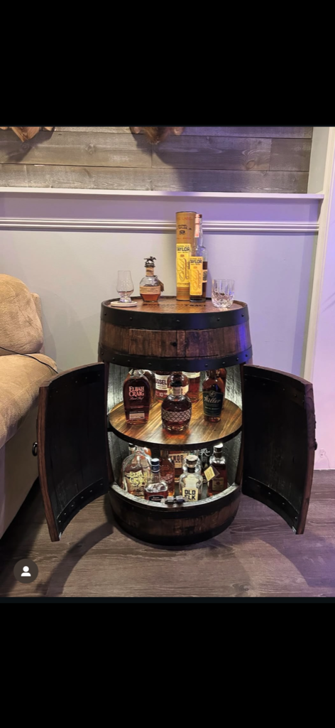 Whiskey barrel liquor cabinet with doors open showing bottles