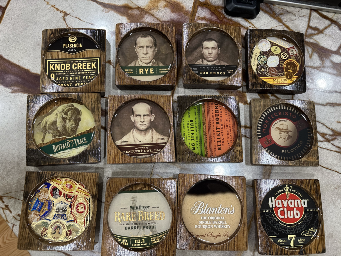 Collection of handcrafted barrel wood coasters with whiskey brand labels